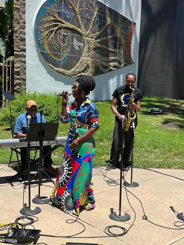 Buki performing outdoors in a colorful dress