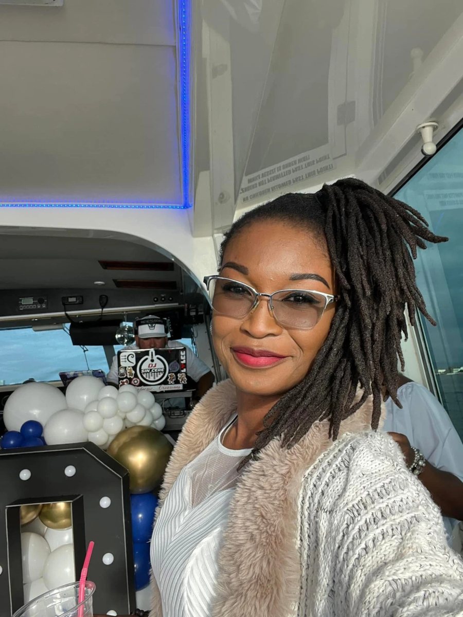 Buki smiling in glasses, taking a selfie at a celebration on a boat